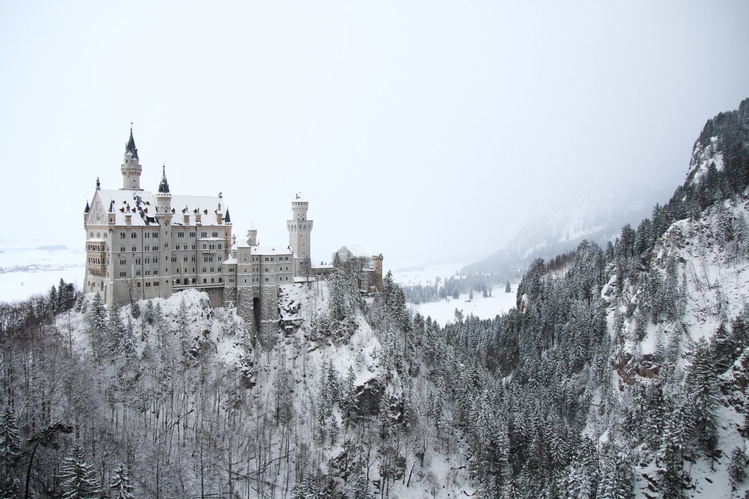 Ein Schloss auf einem Felsen im Wald, bei Schnee
