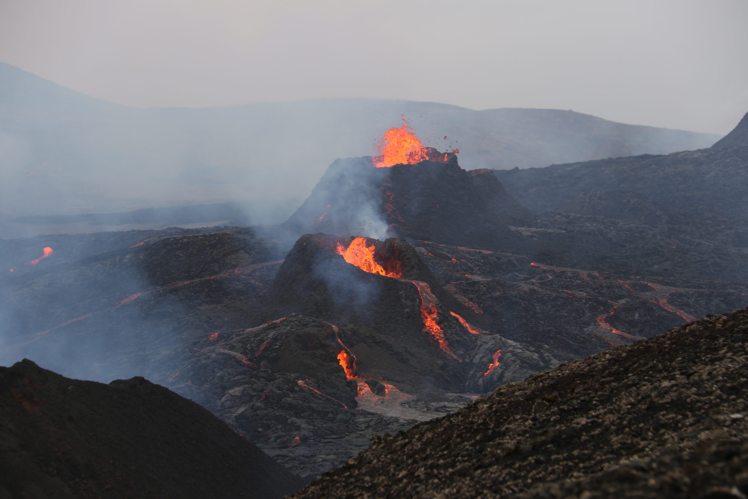 Orangen glühende Lava fließt aus einer Bergspitze