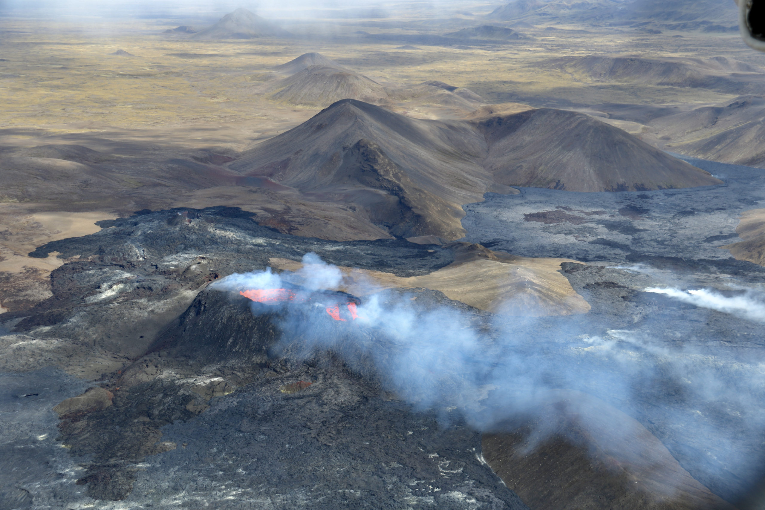 Orangen glühende Lava fließt aus einer Bergspitze