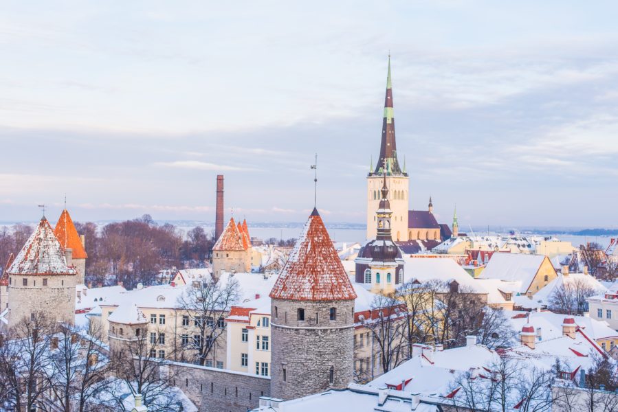 Eine eingeschneite Stadt mit Stadtmauer und Kirchturm.