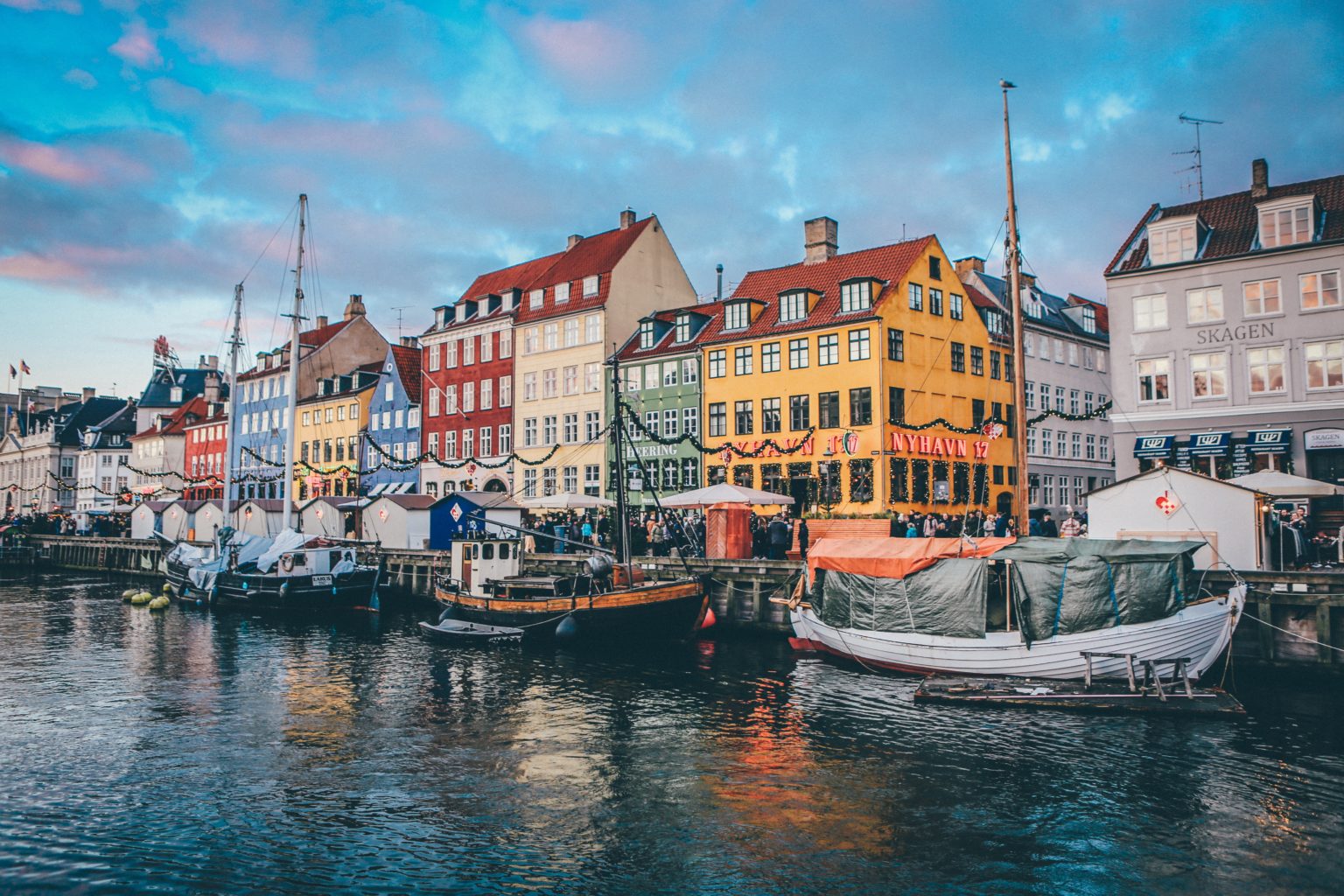 Bunte Häuserfassaden und kleine Boote an einem Fluss in der Stadt