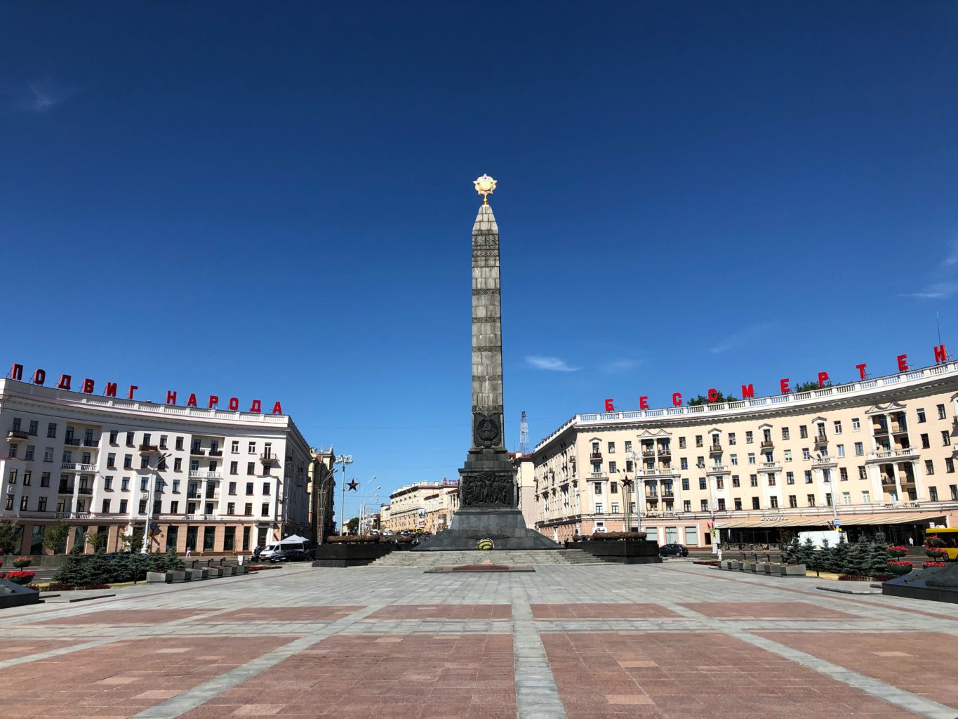 Eine riesige Säule steht als Wahrzeichen auf einem gepflasterten Platz